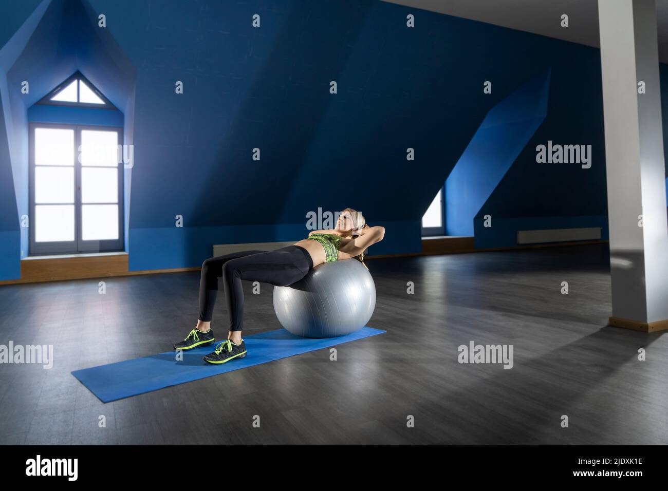 Frau, die im Fitnessclub auf dem Fitnessball trainiert Stockfoto