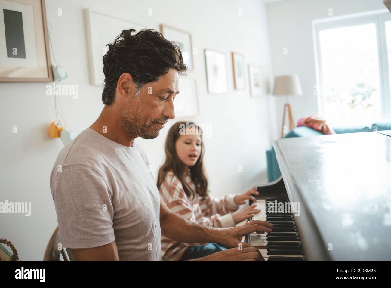Vater und Tochter spielen zu Hause zusammen Klavier Stockfoto