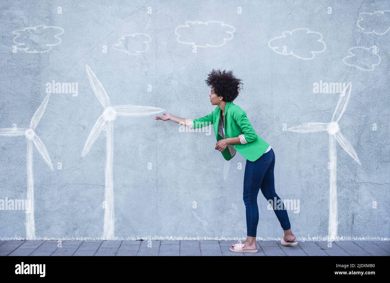 Frau erklärt Windturbinen gemalt an der Wand Stockfoto