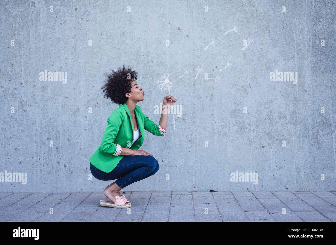 Hockende Frau weht gemalt Schlag Kugel Blume Stockfoto