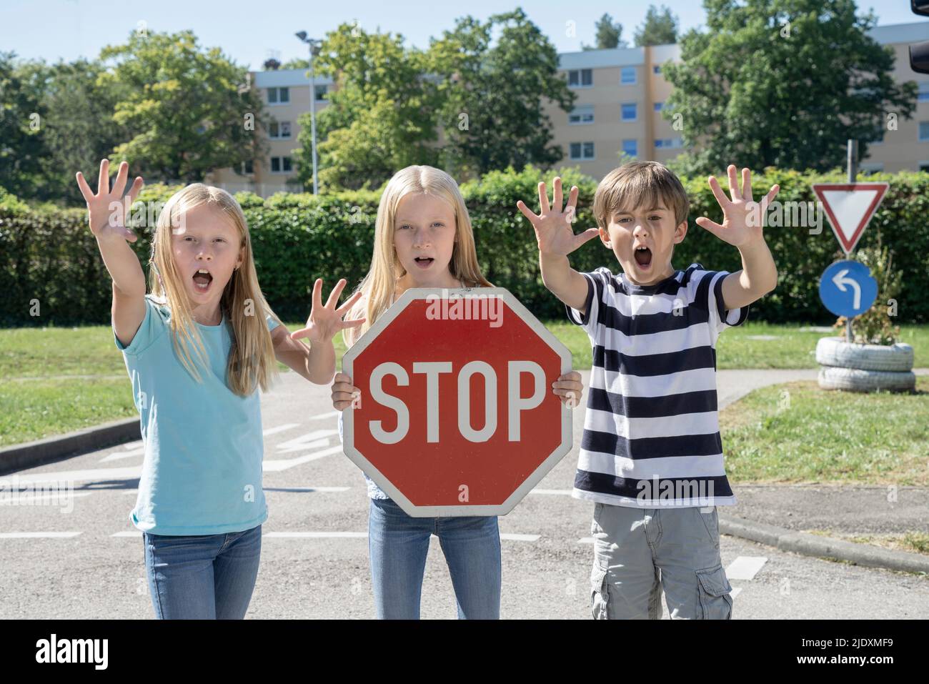 Mädchen hält Stop Schild von Freunden an sonnigen Tag stehen Stockfoto