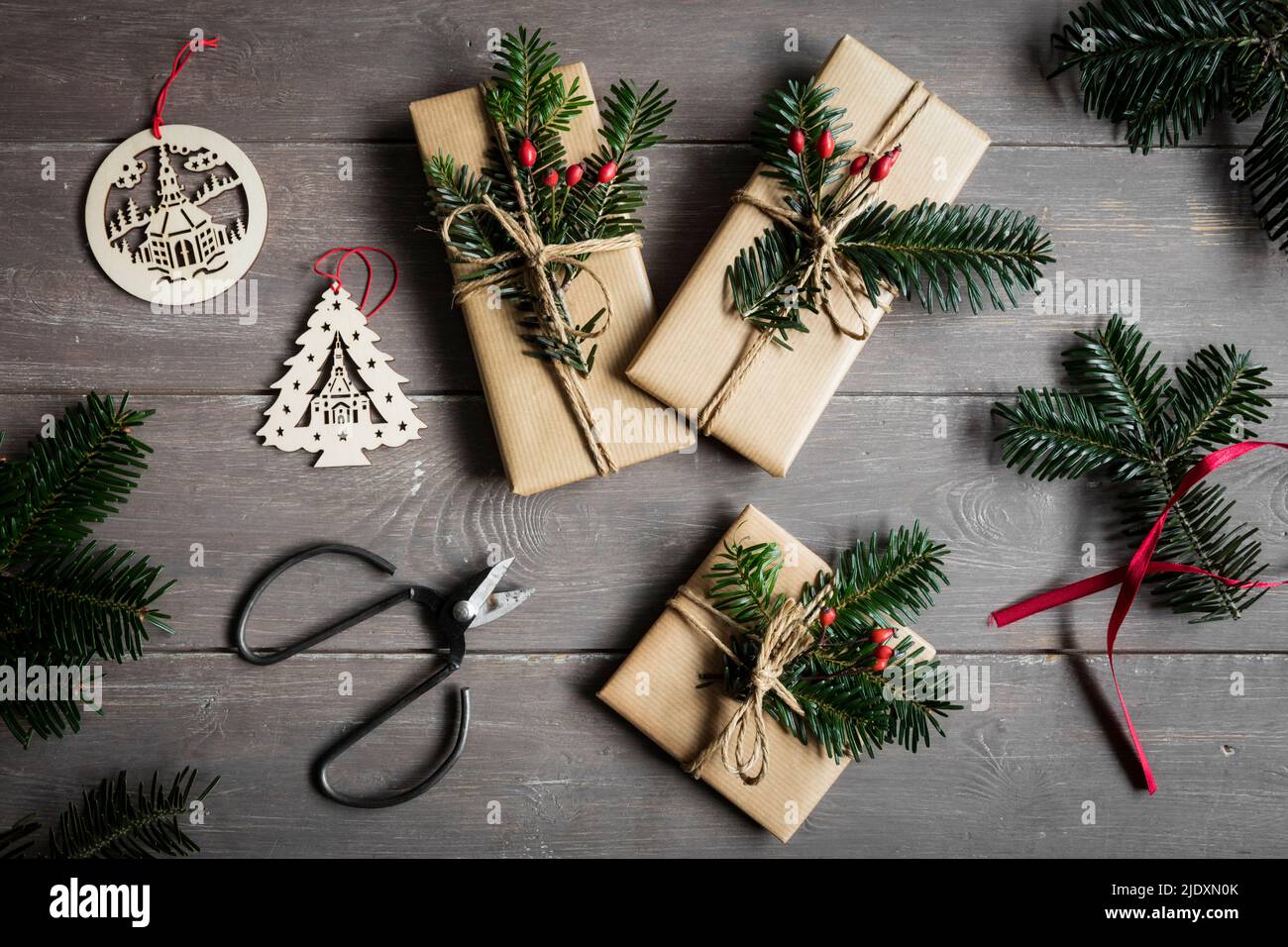 Studioaufnahme von natürlich gewickelten Weihnachtsgeschenken, die mit Fichtenzweigen verziert sind Stockfoto
