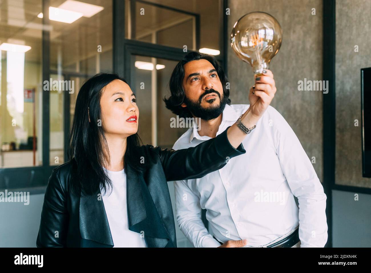 Reife Kollegen aus dem Unternehmen analysieren Glühbirne im Büro Stockfoto