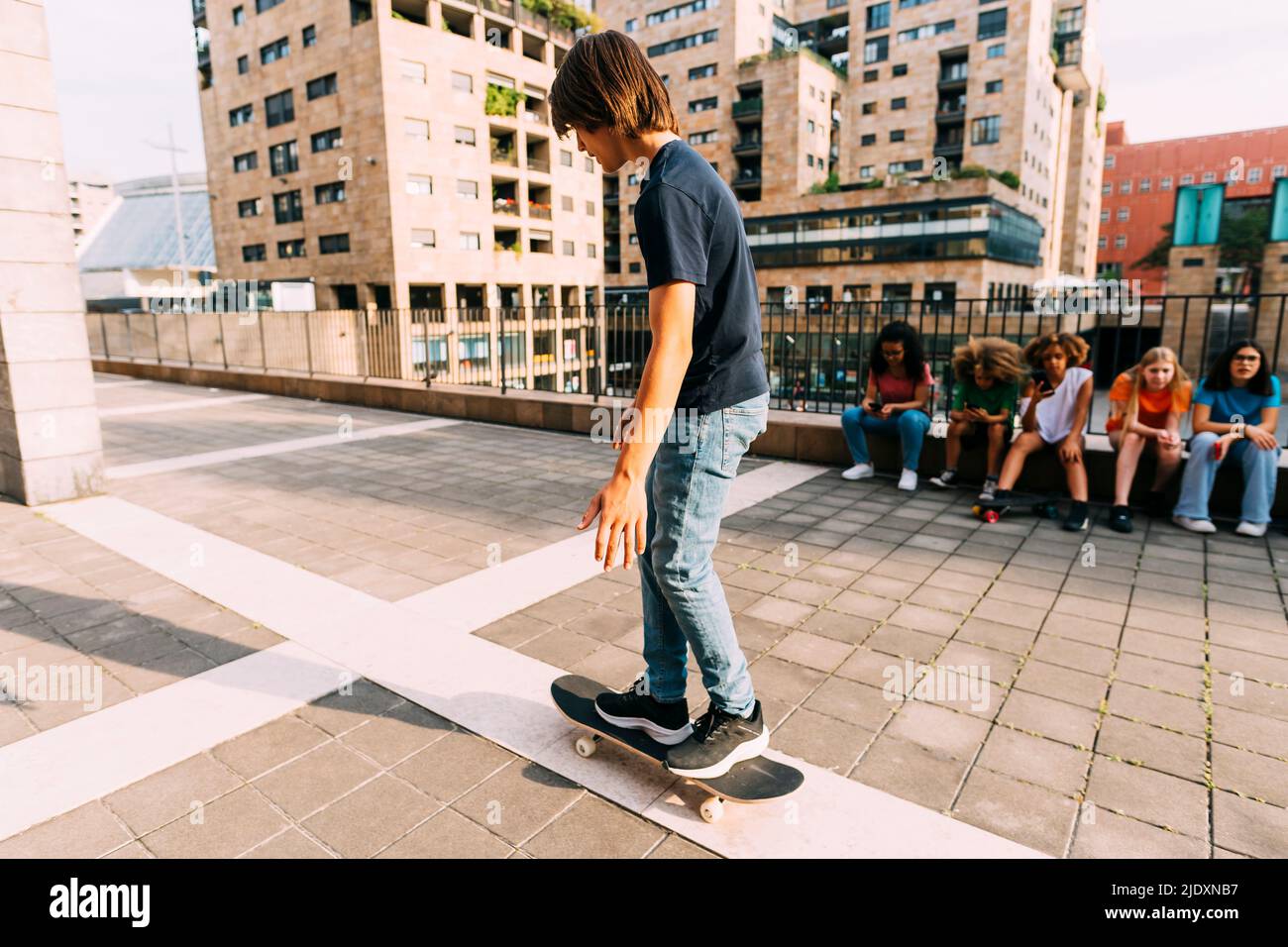 Boy Skateboarding Parkplatz an sonnigen Tag Stockfoto