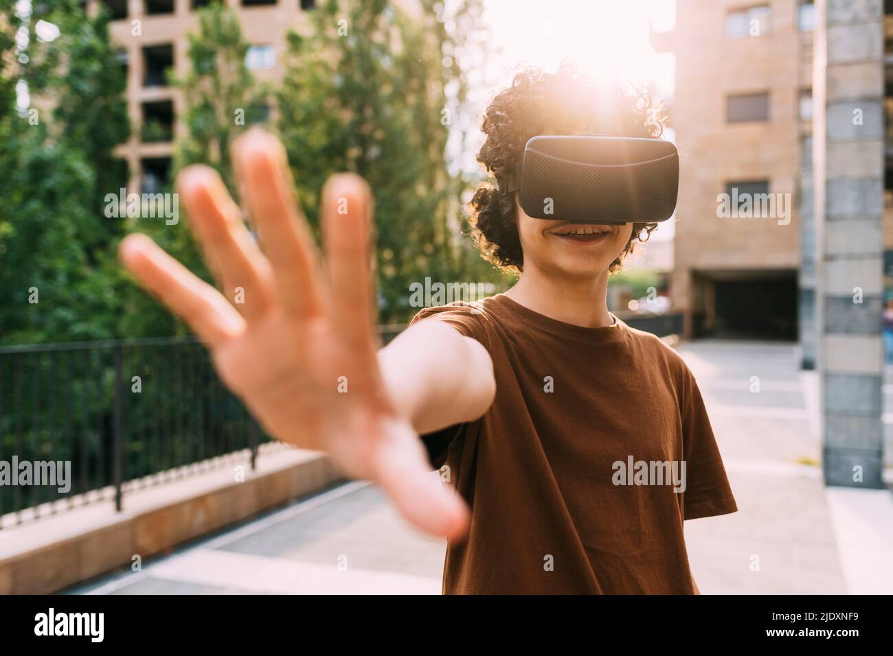 Lächelnder Junge trägt Virtual Reality-Simulator gestikuliert Stockfoto