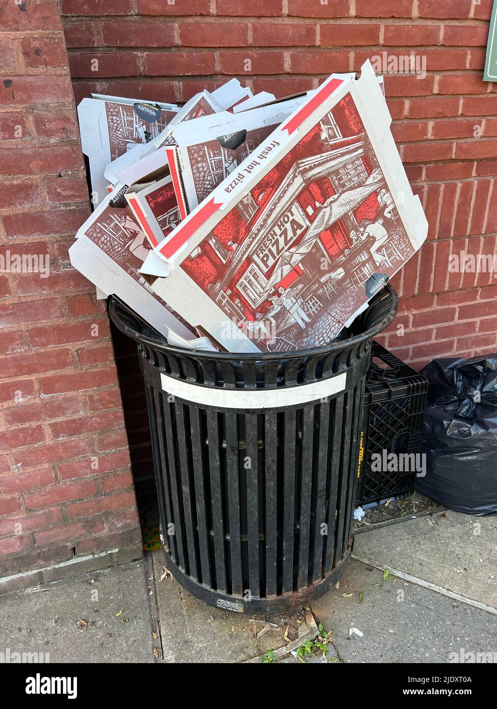 Leere Pizzakisten, die ein Hauptnahrungsmittel aus New York City vor einem Gebäude in Brooklyn widerspiegeln. Stockfoto