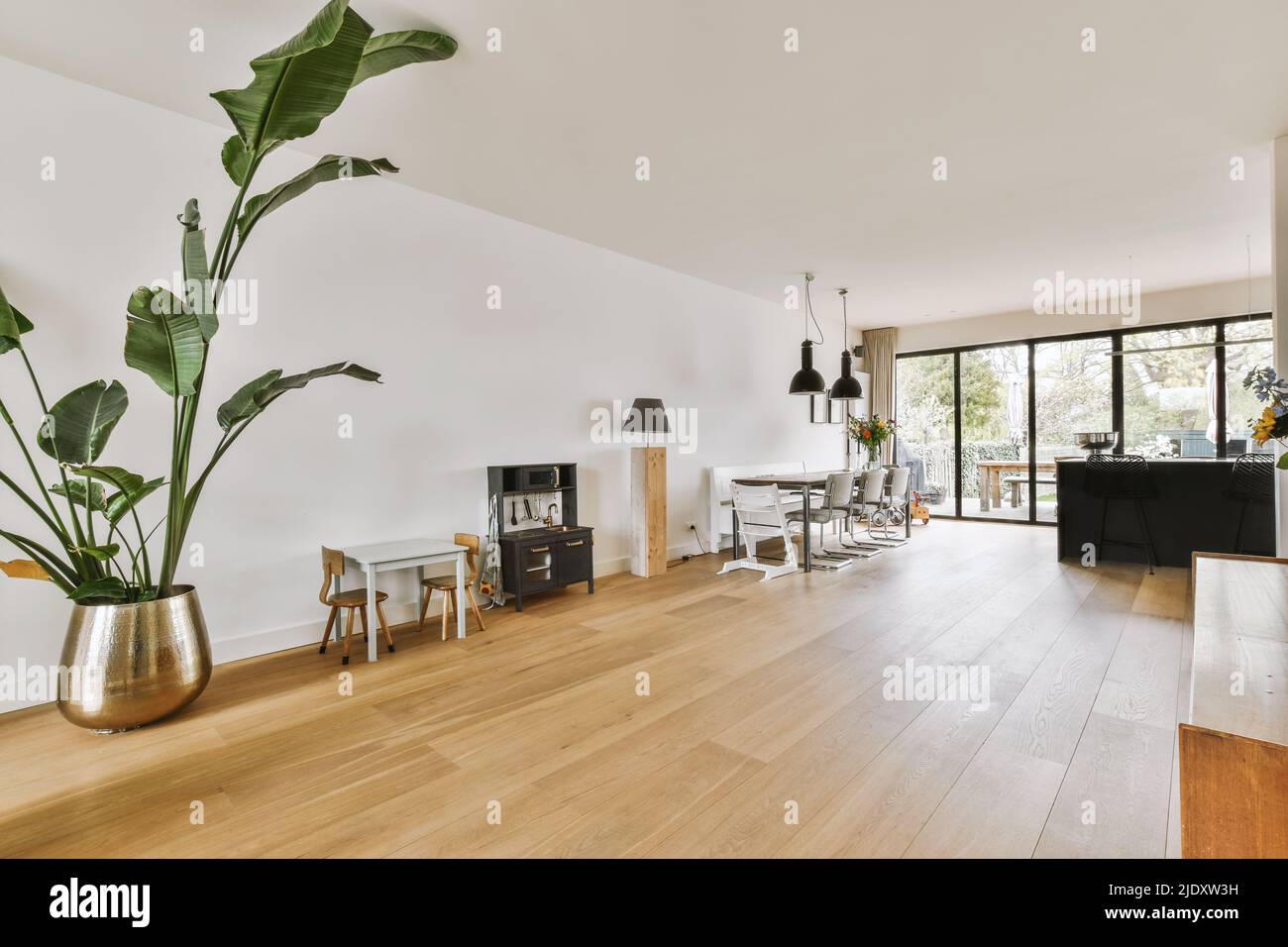Die Einrichtung eines hellen Raums mit stilvollen Ess- und Loungebereichen in einem modernen Haus tagsüber Stockfoto
