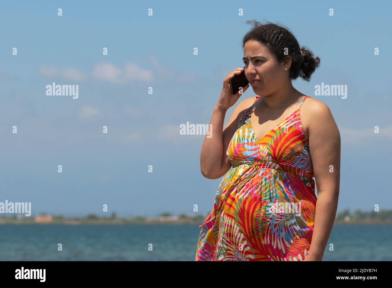 Schwanger Frau hört auf ihr Telefon. Schwangerschaft und Diversität Konzept. Stockfoto