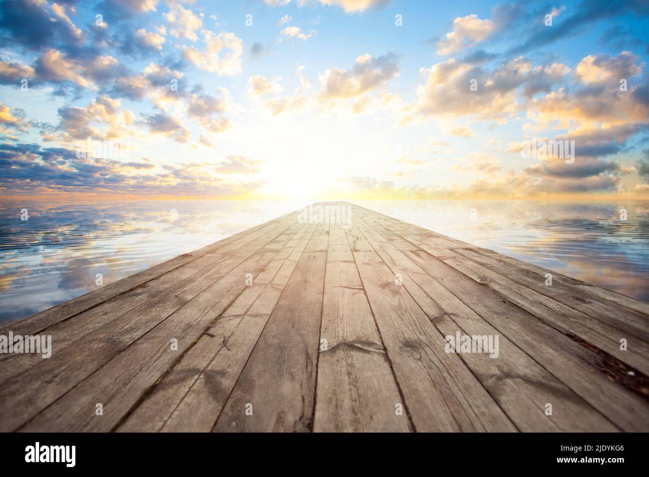 Alte hölzerne Anlegestelle am kleinen Fluss mit dramatischem Sonnenaufgang, Himmel und Wolken. Lebendige Farben. Stockfoto