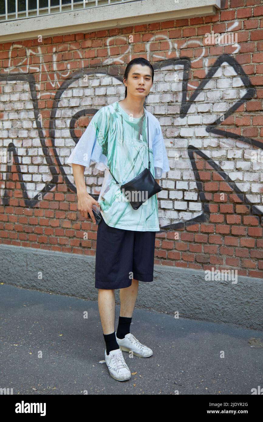MAILAND, ITALIEN - 18. JUNI 2022: Mann mit türkisfarbenem T-Shirt und schwarzen Shorts vor der Fendi-Modenschau im Street-Style der Milan Fashion Week Stockfoto