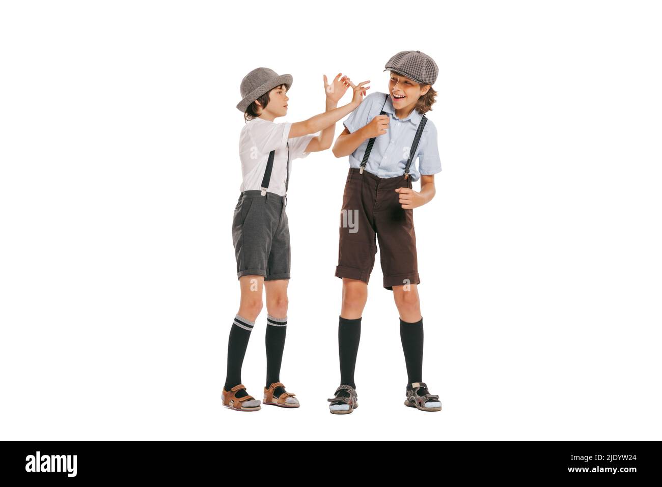Zwei Jungen im Schulalter, stilvolle Kinder tragen Retro-Kleidung isoliert auf weißem Hintergrund. Konzept der Kindheit, Vintage Sommer Mode Stil Stockfoto