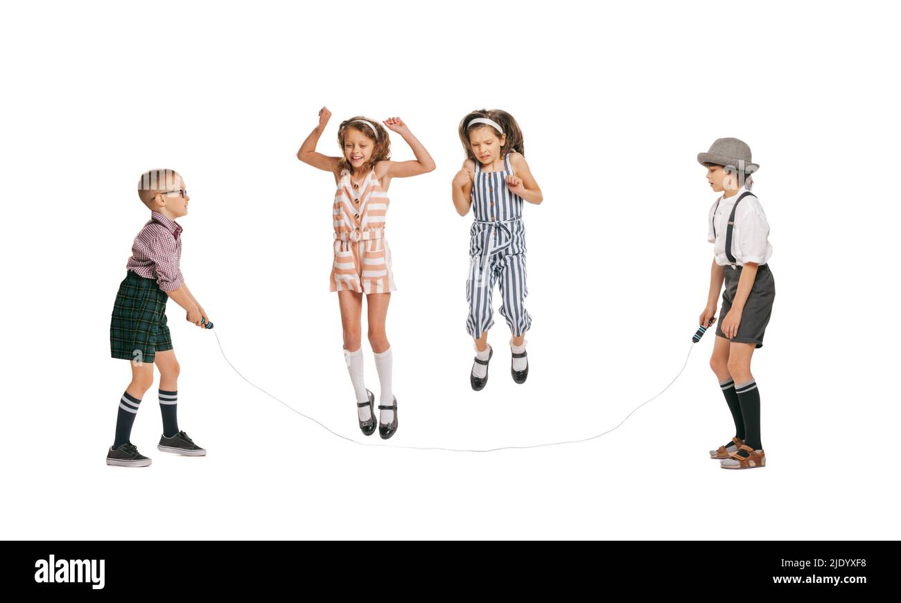 Gruppe von fröhlichen Kindern im Retro-Stil Sommer-Outfit springen isoliert auf weißem Hintergrund. Konzept von Kunst, Freundschaft, Hoffnung, Jugend, Mode Stockfoto