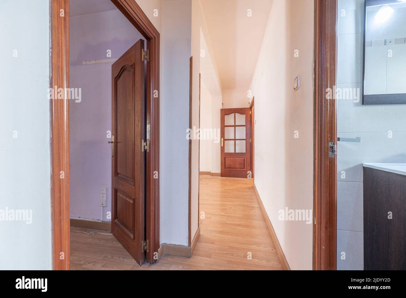 Verteilergang eines Hauses mit hellem Eichenboden und rötlichen Holzschreinerarbeiten an den Türen Stockfoto