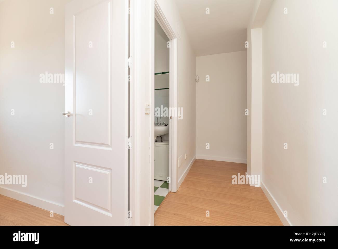 Flur eines Hauses mit hellem Eichenboden mit Zugangstüren zu verschiedenen Zimmern und weißer Holzschreinerei Stockfoto
