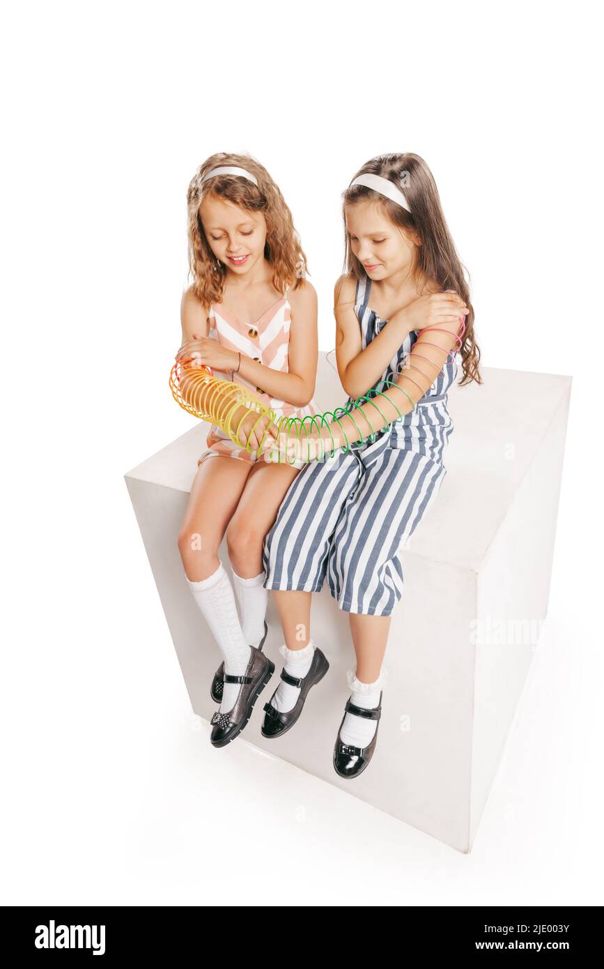 High-Angle-Ansicht von zwei fröhlichen Mädchen im Retro-Stil Sommer-Outfit isoliert auf weißem Hintergrund. Konzept von Kunst, Freundschaft, Hoffnung, Jugend, Mode Stockfoto