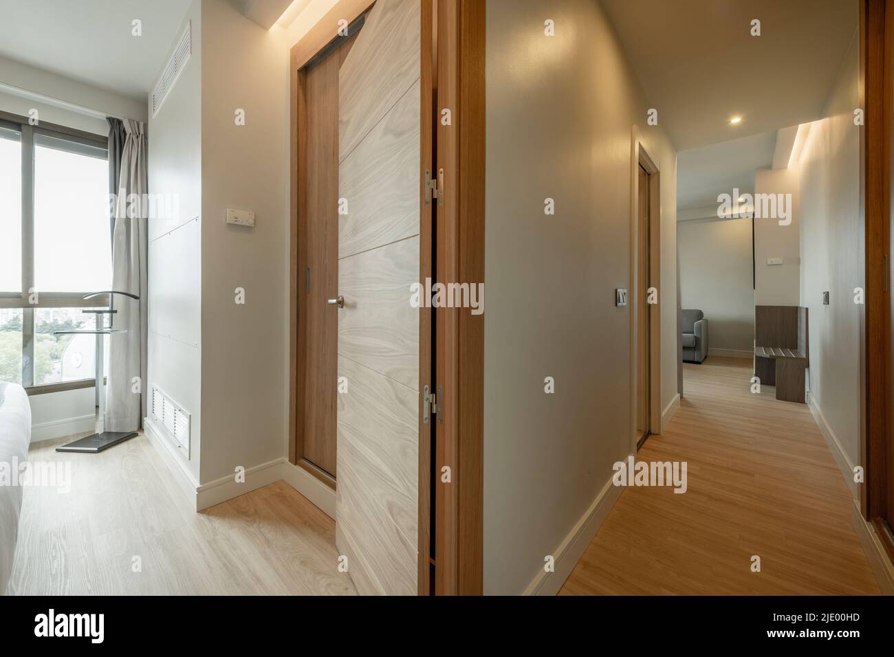 Wohnzimmer Korridor mit hellen Eichenböden, passende Türschreinerei und große Fenster mit Aussicht Stockfoto