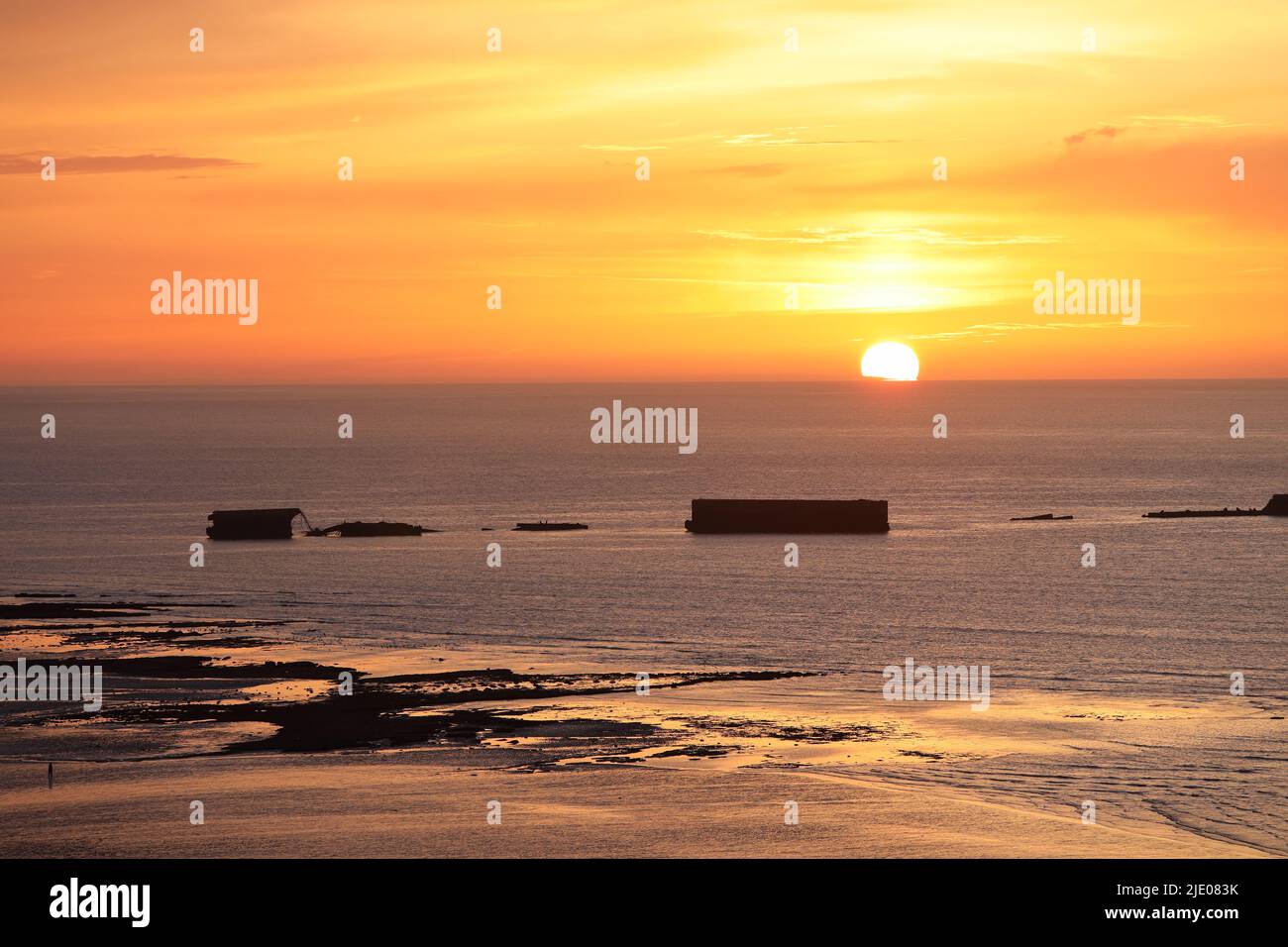 Sonnenuntergang über den Überresten des Mulberry Harbour von WW2 am Gold Beach, Arromanches-les-Bains, Normandie, Frankreich Stockfoto