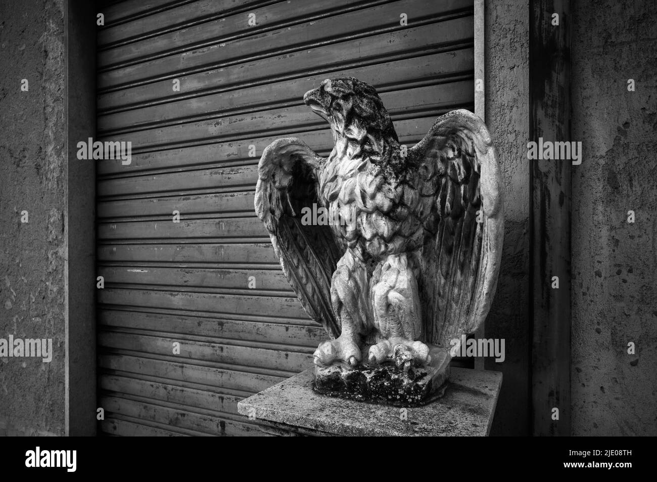 Skulptur eines Adlers vor einem geschlossenen Laden, Gaggi, Sizilien, Italien Stockfoto