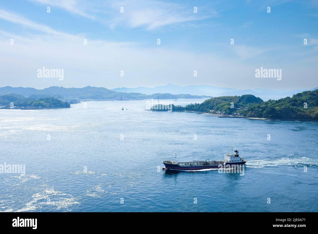 Ein Schiff befährt das japanische Binnenmeer (Seto Naikai), von der Kurushima-Kaikyō-Brücke aus gesehen, die die Insel Ōshima mit Shikoku verbindet. Stockfoto