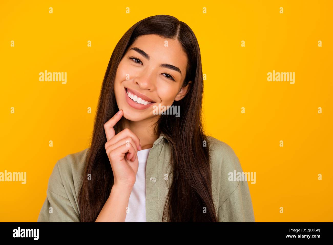 Foto von wunderschönen positiven Person Finger berühren Kinn toothy strahlendes Lächeln isoliert auf gelbem Hintergrund Stockfoto