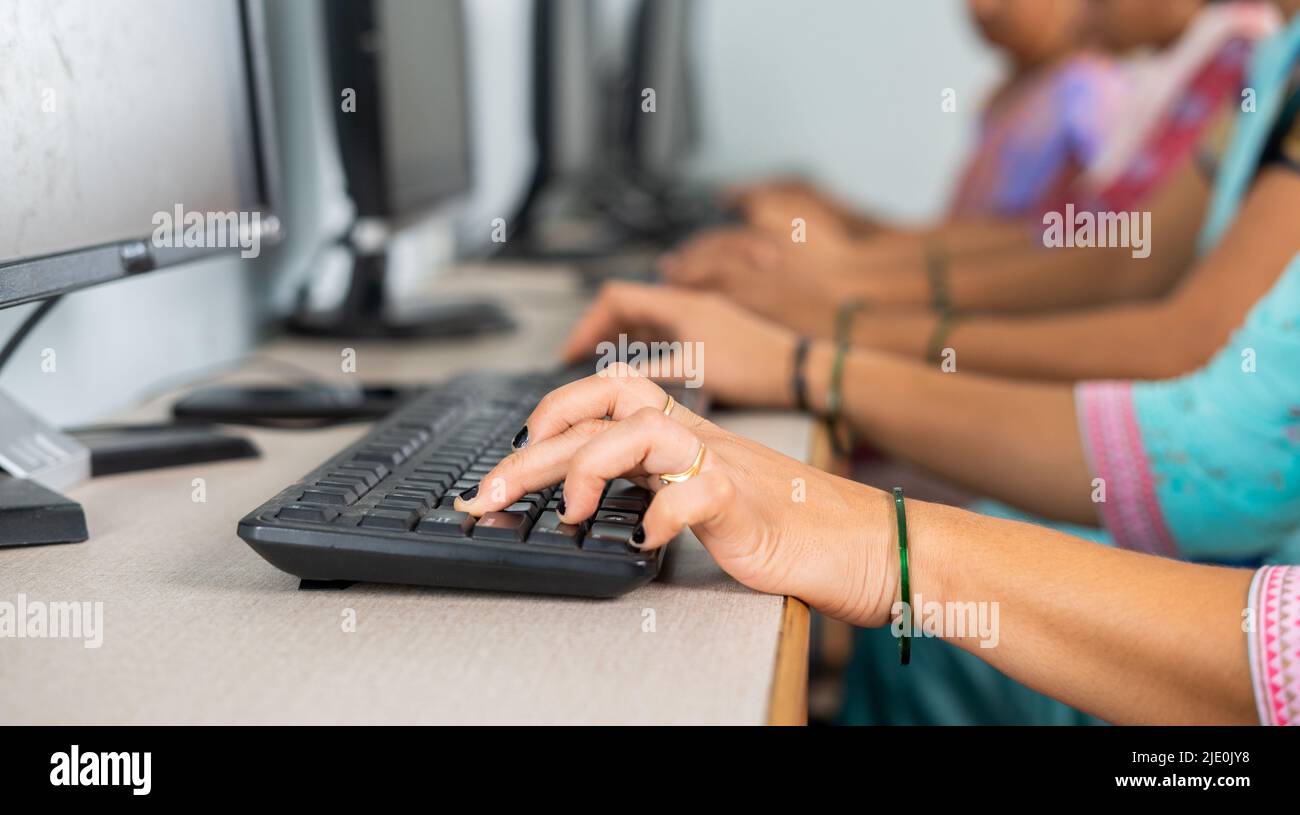 Nahaufnahme einer Gruppe von Frauen, die mit dem Lernen oder Arbeiten am Computer im Trainingszentrum beschäftigt sind, indem sie tippen - Konzept der Ermächtigung, des Lernens und Stockfoto