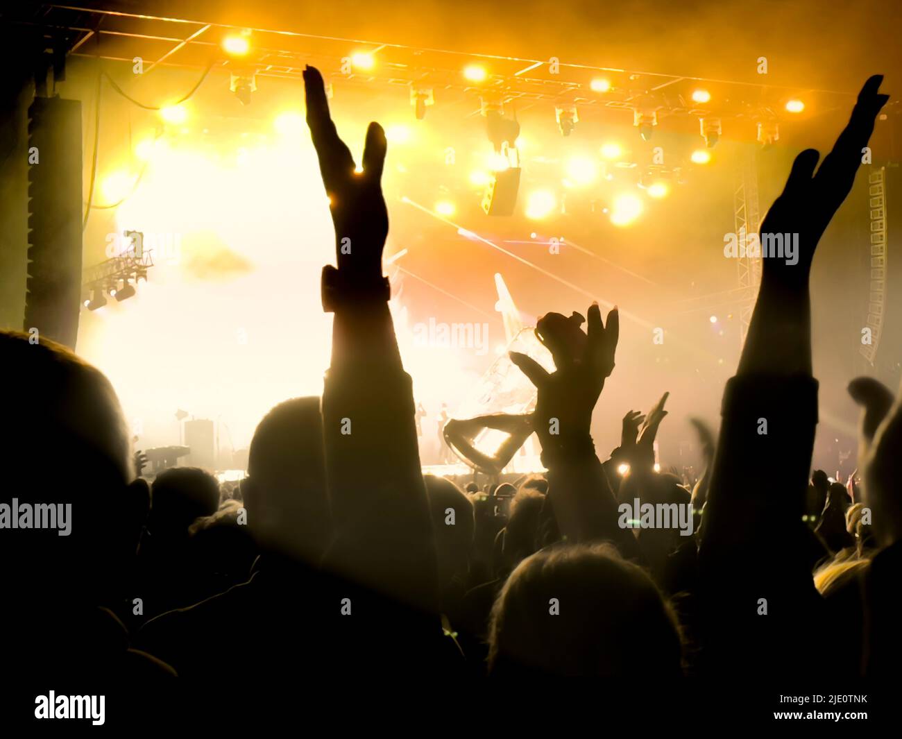 Silhouettierte Menge bei einem Musikkonzert Publikum mit der Bühne im Hintergrund. Stockfoto