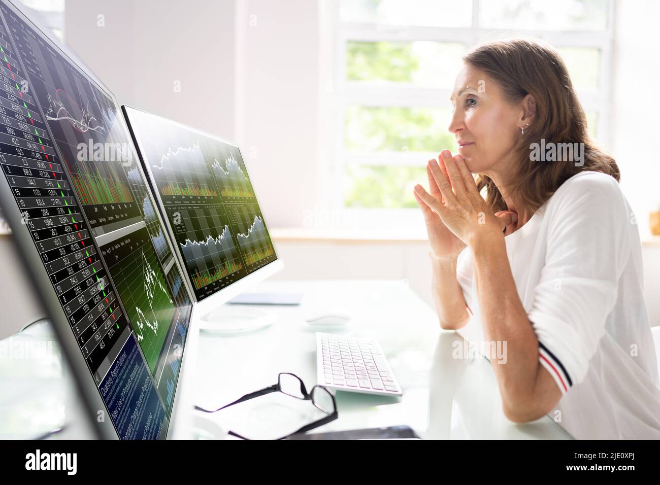 Aktienmarktanalyst Am Office Desk Mit Mehreren Bildschirmen Stockfoto