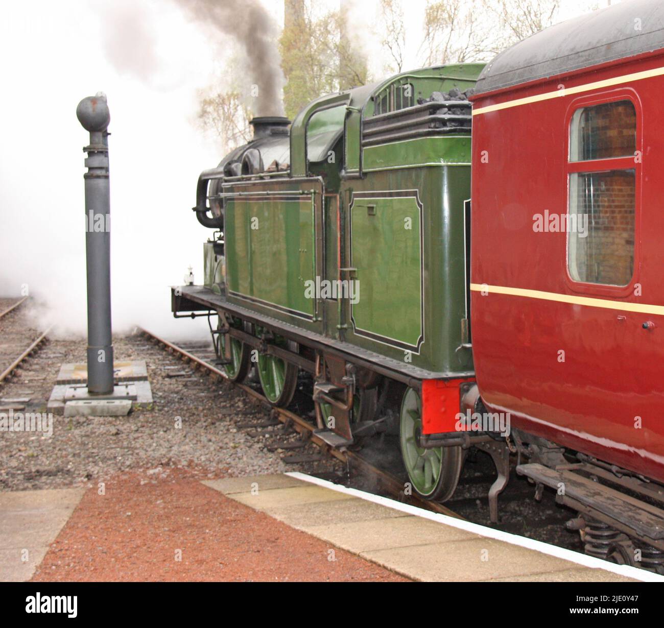 Ein historischer Dampfzug, der vom Bahnhof wegfährt. Stockfoto