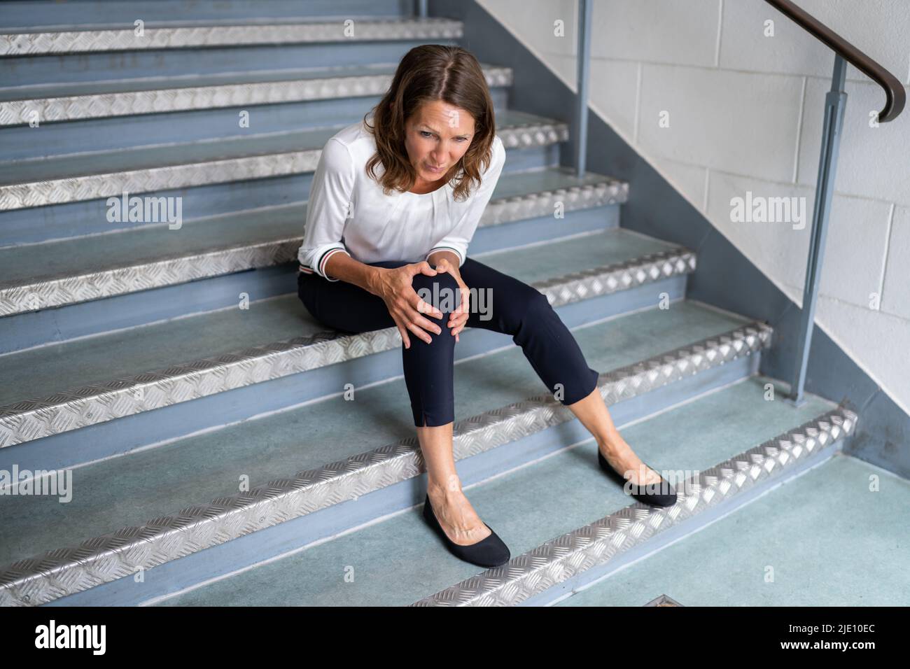 Reife Frau Sitzt Auf Der Treppe Nach Slip Und Fall Unfall Stockfoto