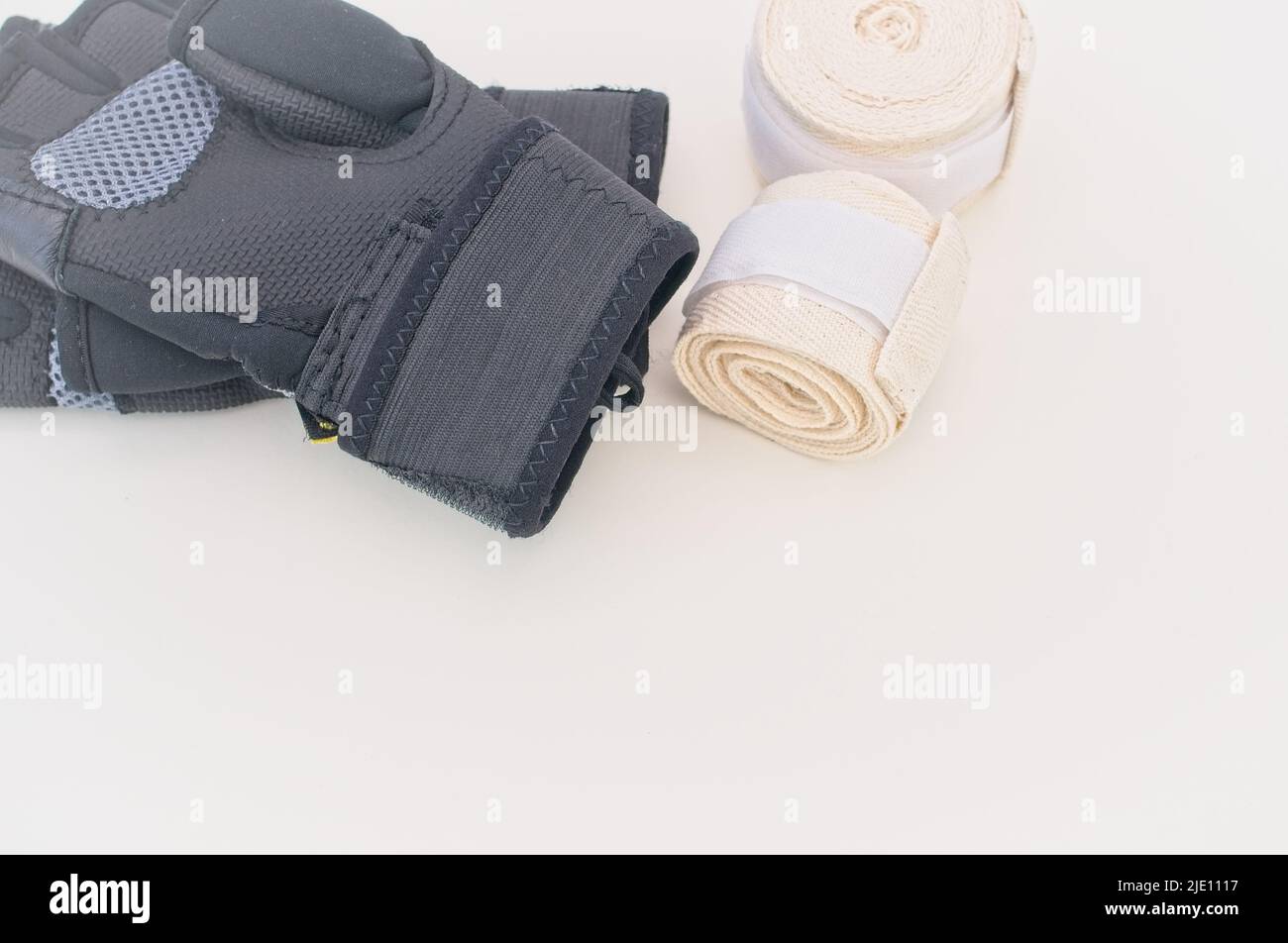 Boxausrüstung auf einer hellen Schreibtischoberfläche, Handschuhe und Handwickel Stockfoto