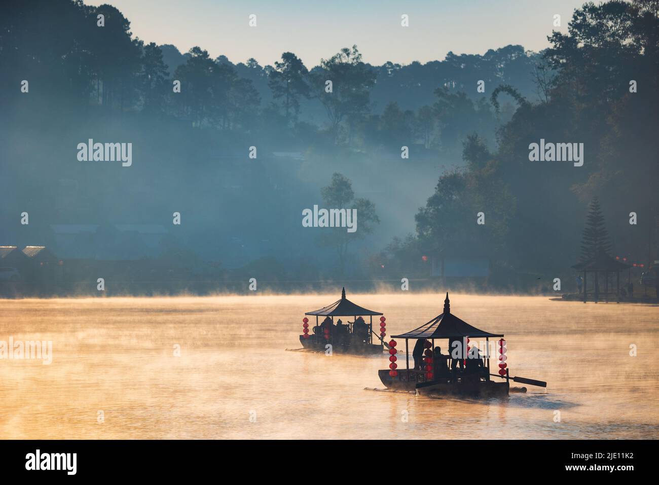 Chinesisches Touristenruderboot im Morgengrauen mit Nebel über dem Ban Rak Thai Lake, Thailand Stockfoto