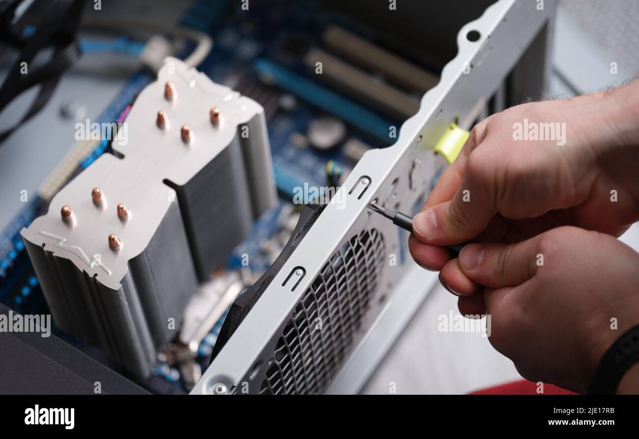 Techniker, der die Stromversorgung des Computers repariert, Nahaufnahme, Demontage des Computers Stockfoto
