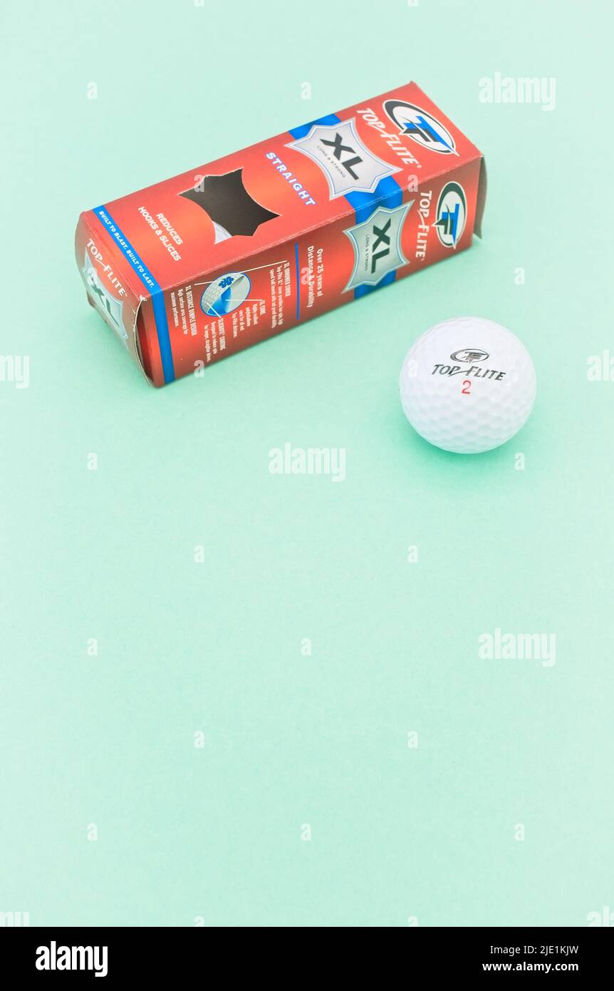 Golfbälle mit Kartons auf einem grünen Schreibtisch mit hellem Wandhintergrund, Platz für Kopien Stockfoto