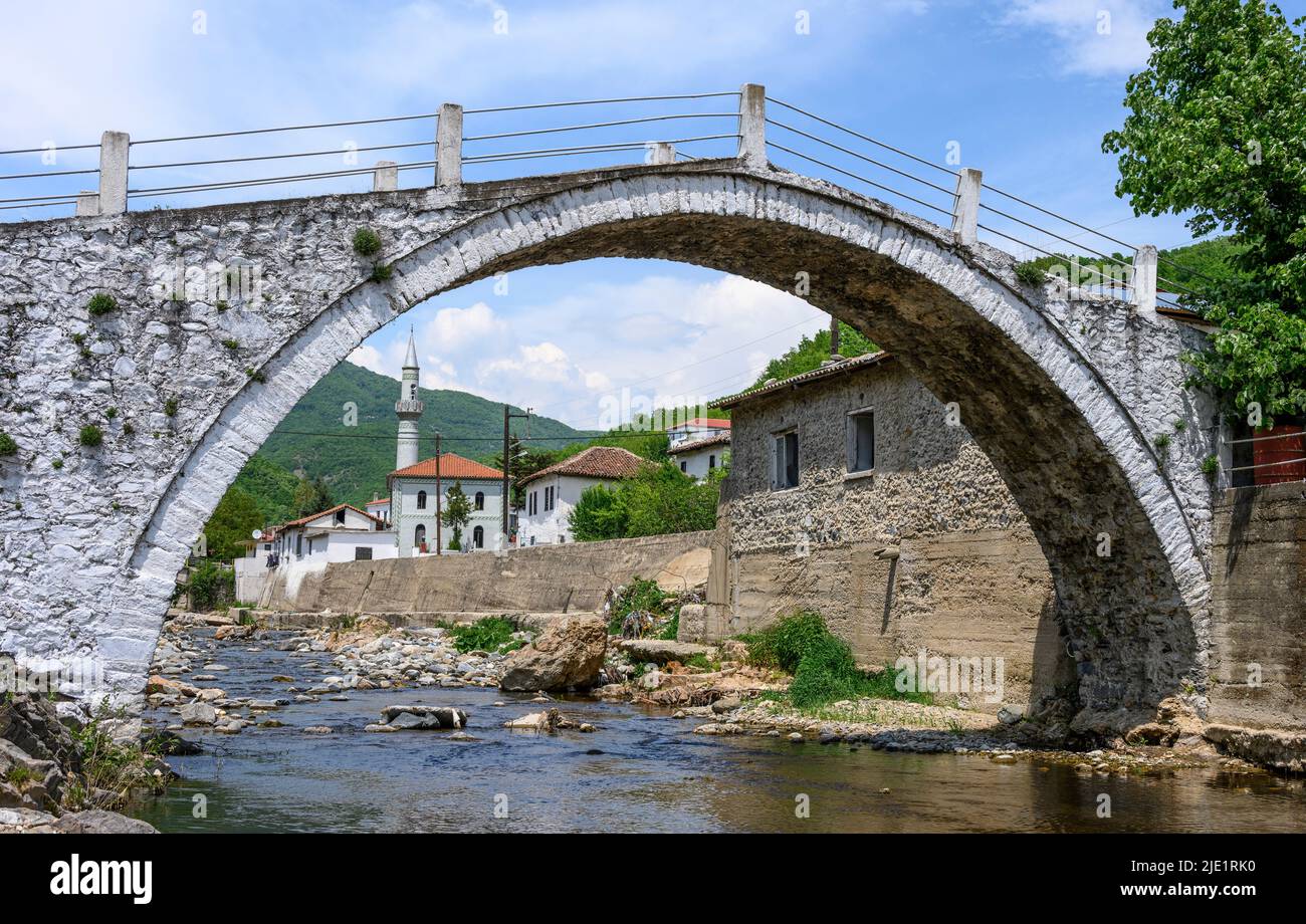 Das Dorf Medousa von Pomak, das durch den Bogen seiner alten Steinbrücke, Thermes Comunity, Xanthi Region, Westthrakien, Griechenland, gesehen wird. Das Dorf Pomak Stockfoto