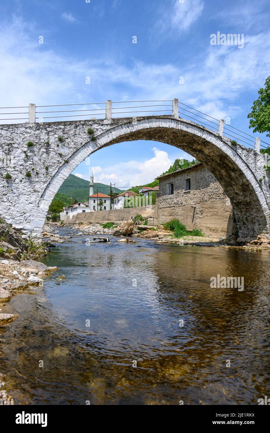 Das Dorf Medousa von Pomak, das durch den Bogen seiner alten Steinbrücke, Thermes Comunity, Xanthi Region, Westthrakien, Griechenland, gesehen wird. Das Dorf Pomak Stockfoto