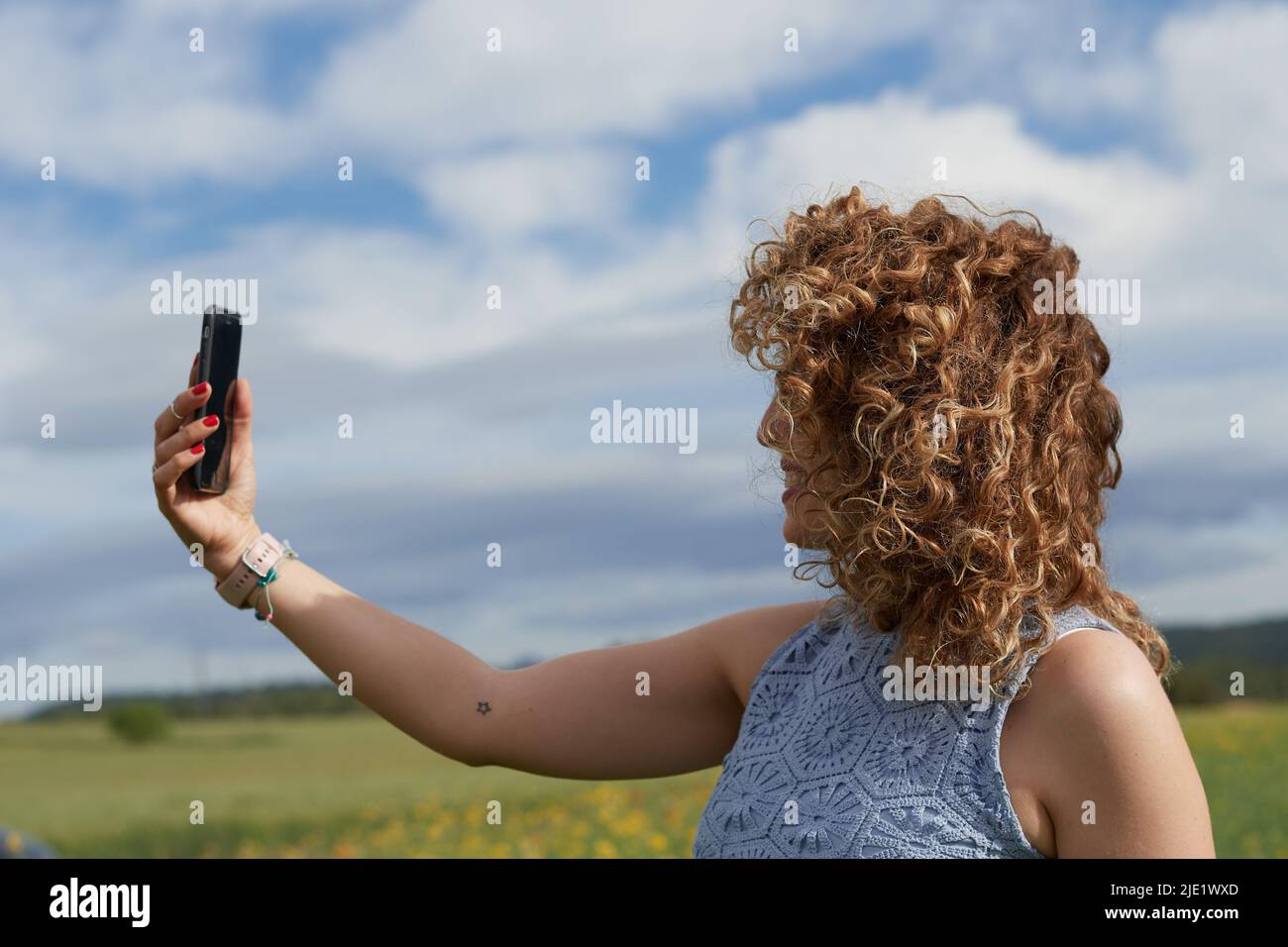 Portrait der schönen glücklichen kaukasischen Mädchen machen Selfie Foto auf dem Smartphone, während im goldenen Feld stehen. Stockfoto