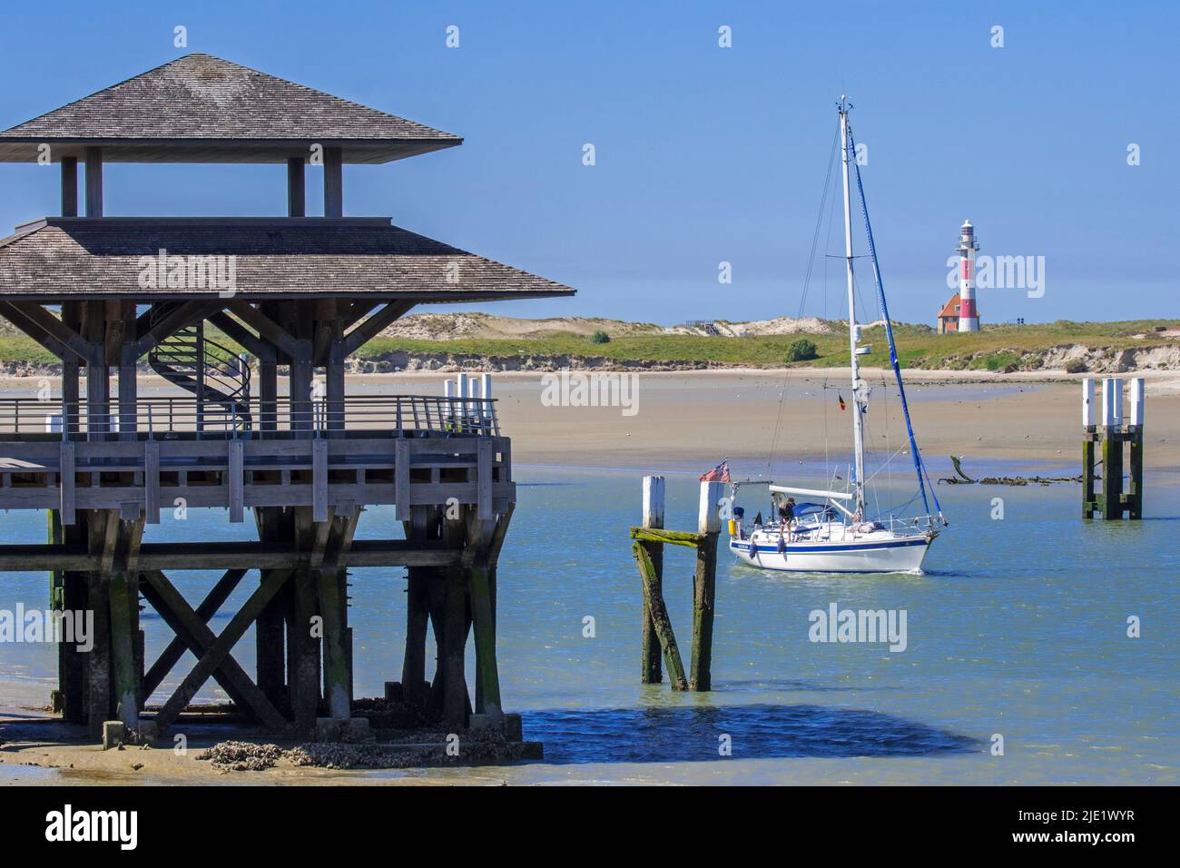 Segelboot, das in den Hafen von Nieuwport / Nieuport einfährt und Aussichtsturm mit Blick auf den Leuchtturm und das Naturschutzgebiet De IJzermonding, Westflandern, Belgien Stockfoto