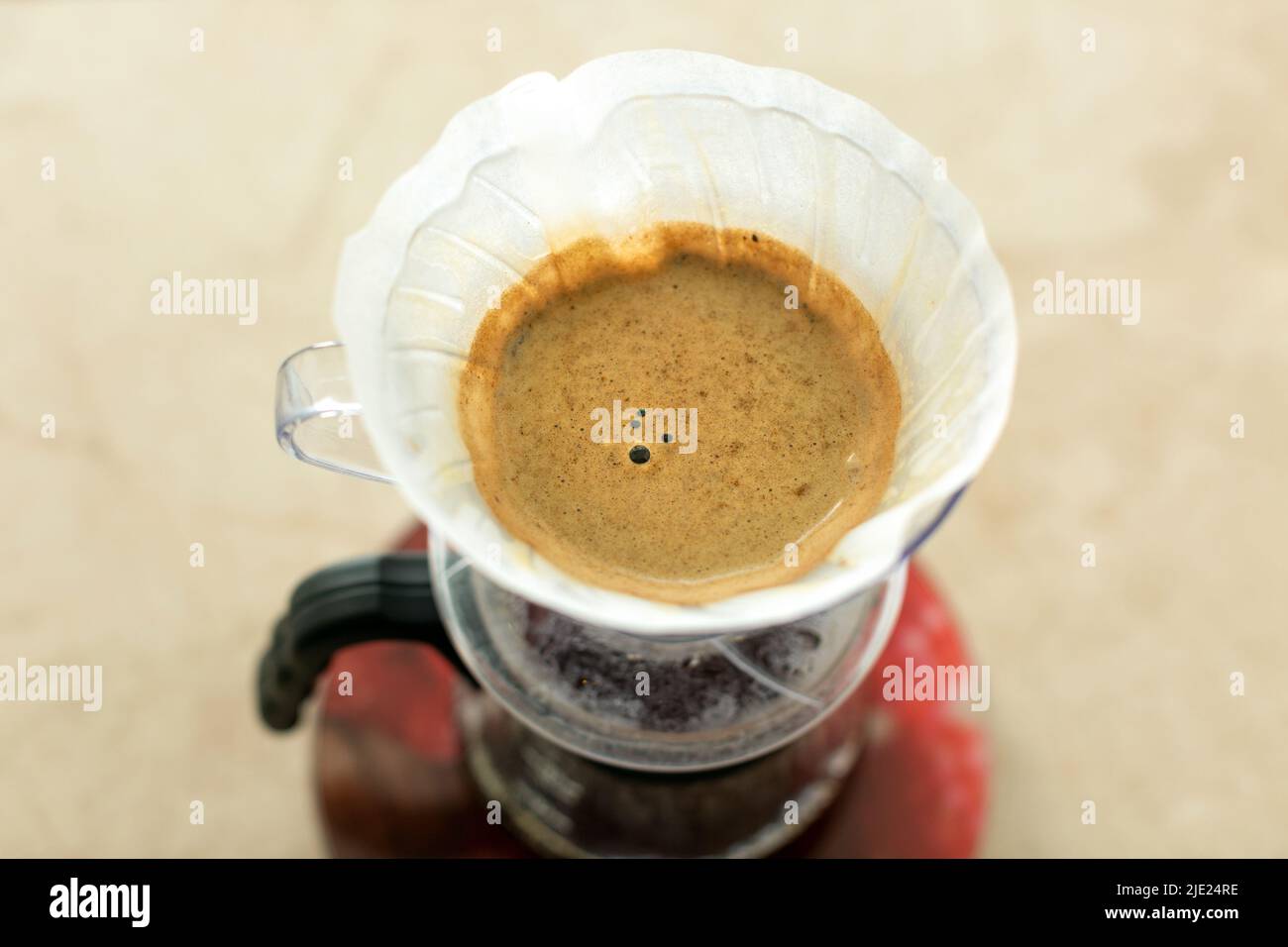 Draufsicht auf eine alternative Methode zur Zubereitung von V60 Kaffee in einem Tropfenkokantier aus Glas. Stockfoto