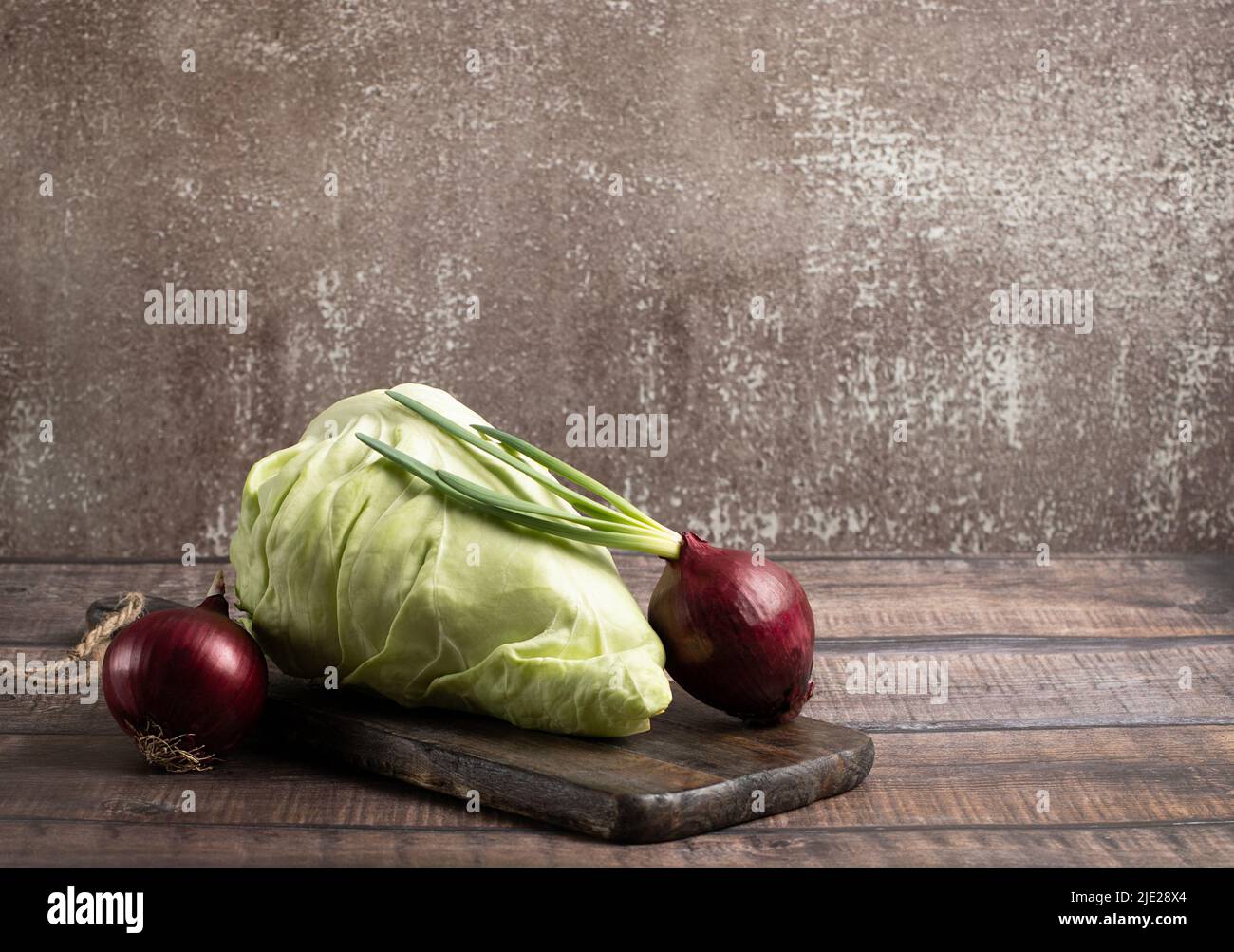 Kegelkopfkohl und Zwiebel für die Ernährung, vegan auf braunem Hintergrund Stockfoto