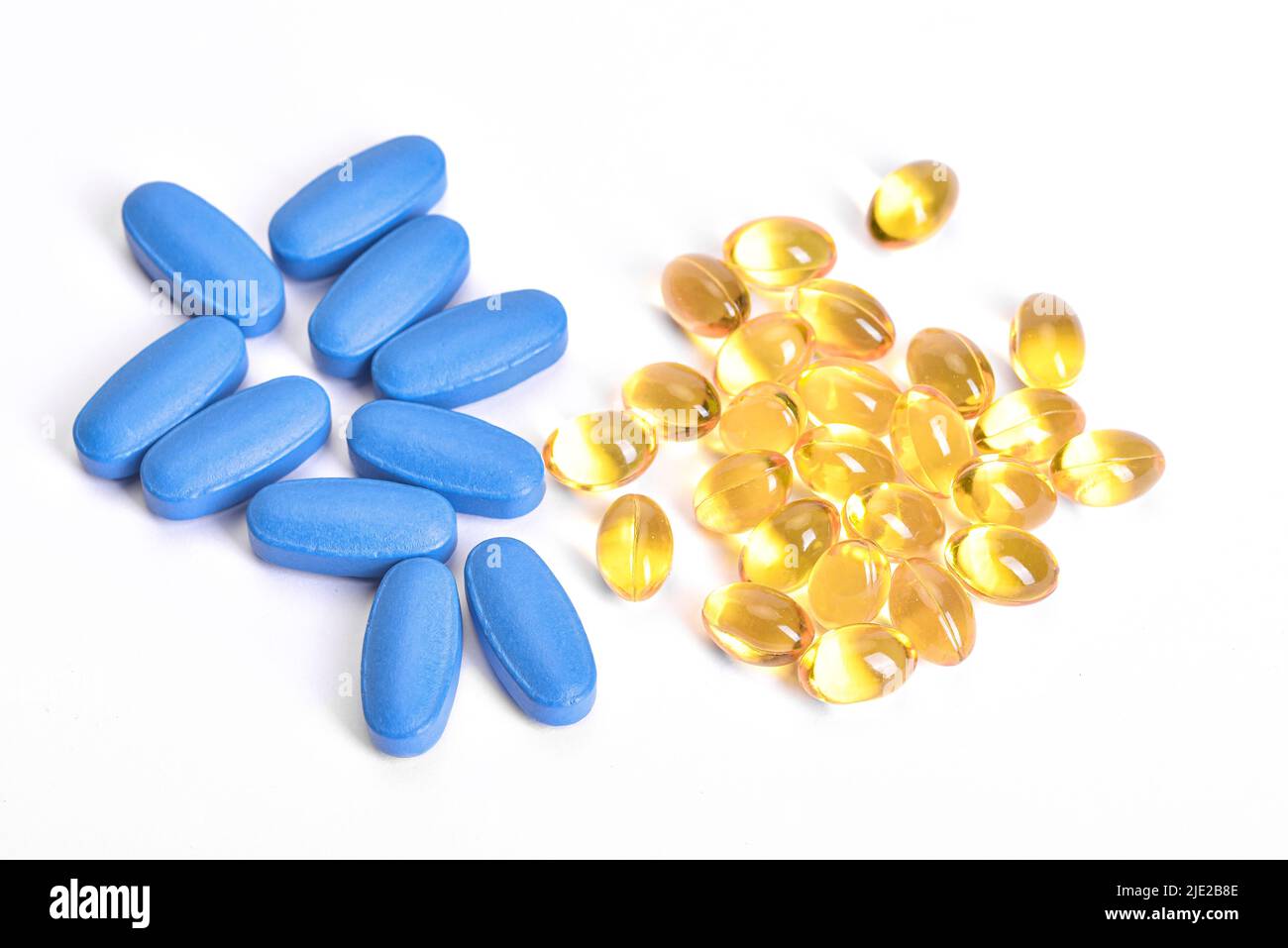 Vitamin D3 Kapseln mit viagra Tabletten Seite an Seite auf weißem Hintergrund. Stockfoto