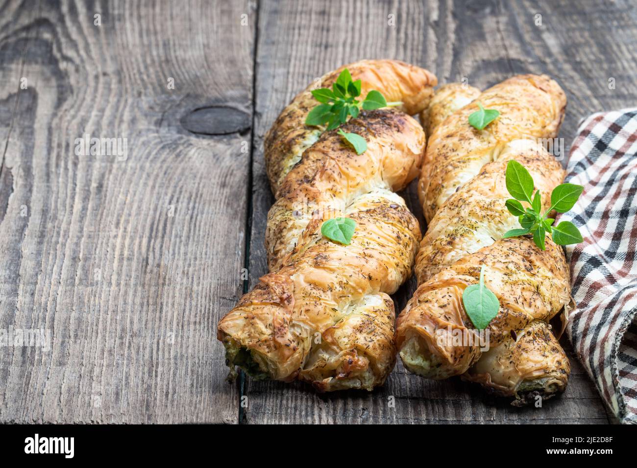 Blätterteiggeflecht, gefüllt mit Hackfleisch auf einem Holztisch Stockfoto