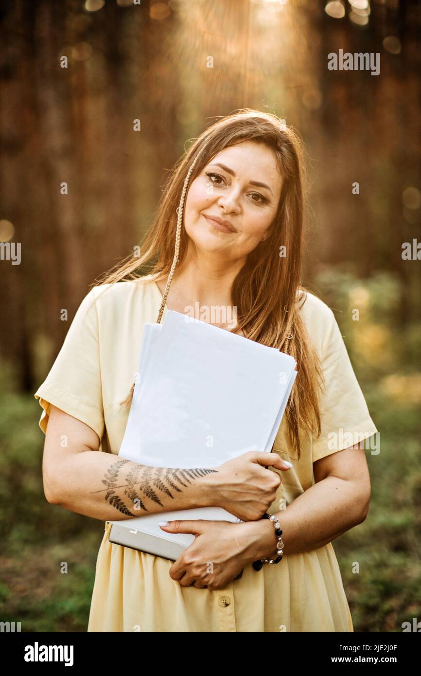 Modell im Freien, bei dem eine Frau ein leeres Papierdokument mit Platz für Kopien in der Hand hält. Stockfoto