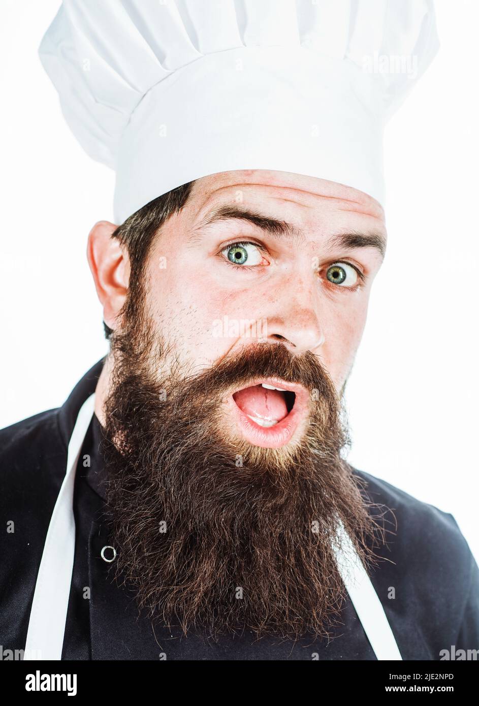 Überraschte den bärtigen Koch in Uniform. Kochen. Emotionen. Porträt eines professionellen männlichen Kochs oder Bäckers. Stockfoto