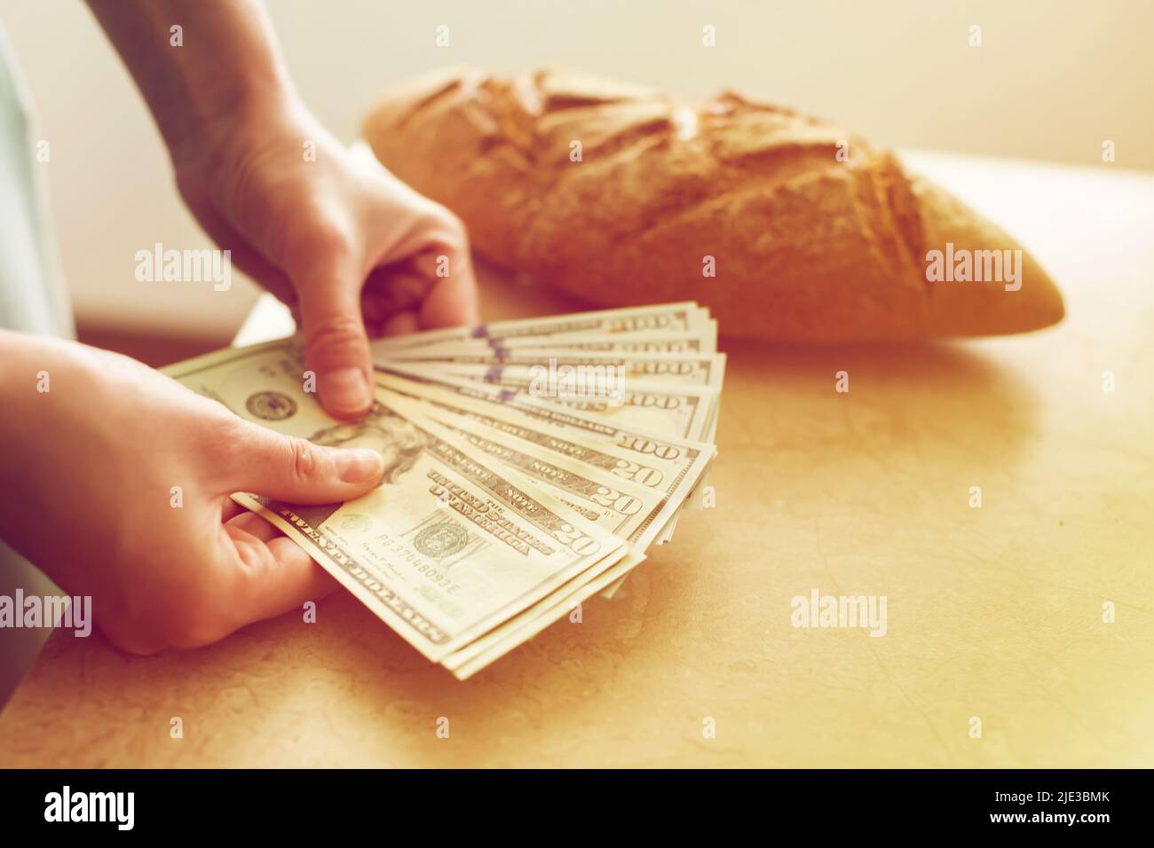 Eine Frau zählt Geld auf dem Hintergrund des Brotes. Finanzierung, Familienbudget-Konzept. Stockfoto