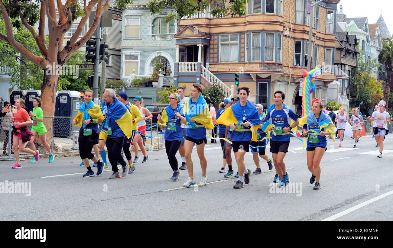 Eine ukrainische Solidaritätsgruppe, die als Tausendfüßler-Tandemteam beim 12k-Fuß-Rennen von Bay to Breakers 2022 in San Francisco, Kalifornien, läuft. Stockfoto