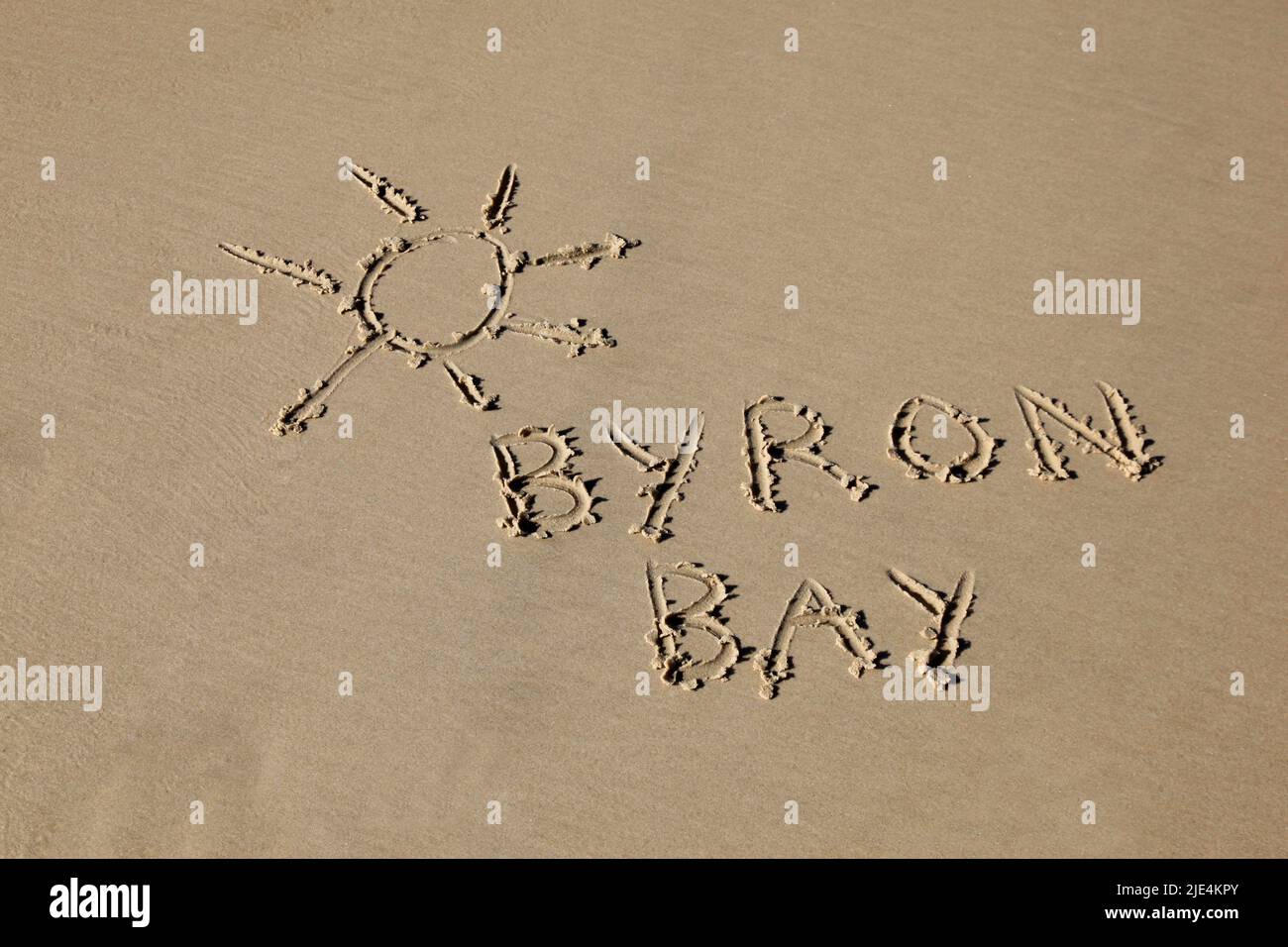 Byron Bay im Sand am Strand geschrieben. Byron Bay ist ein sehr beliebtes Touristenziel am Strand in New South Wales, Australien Stockfoto