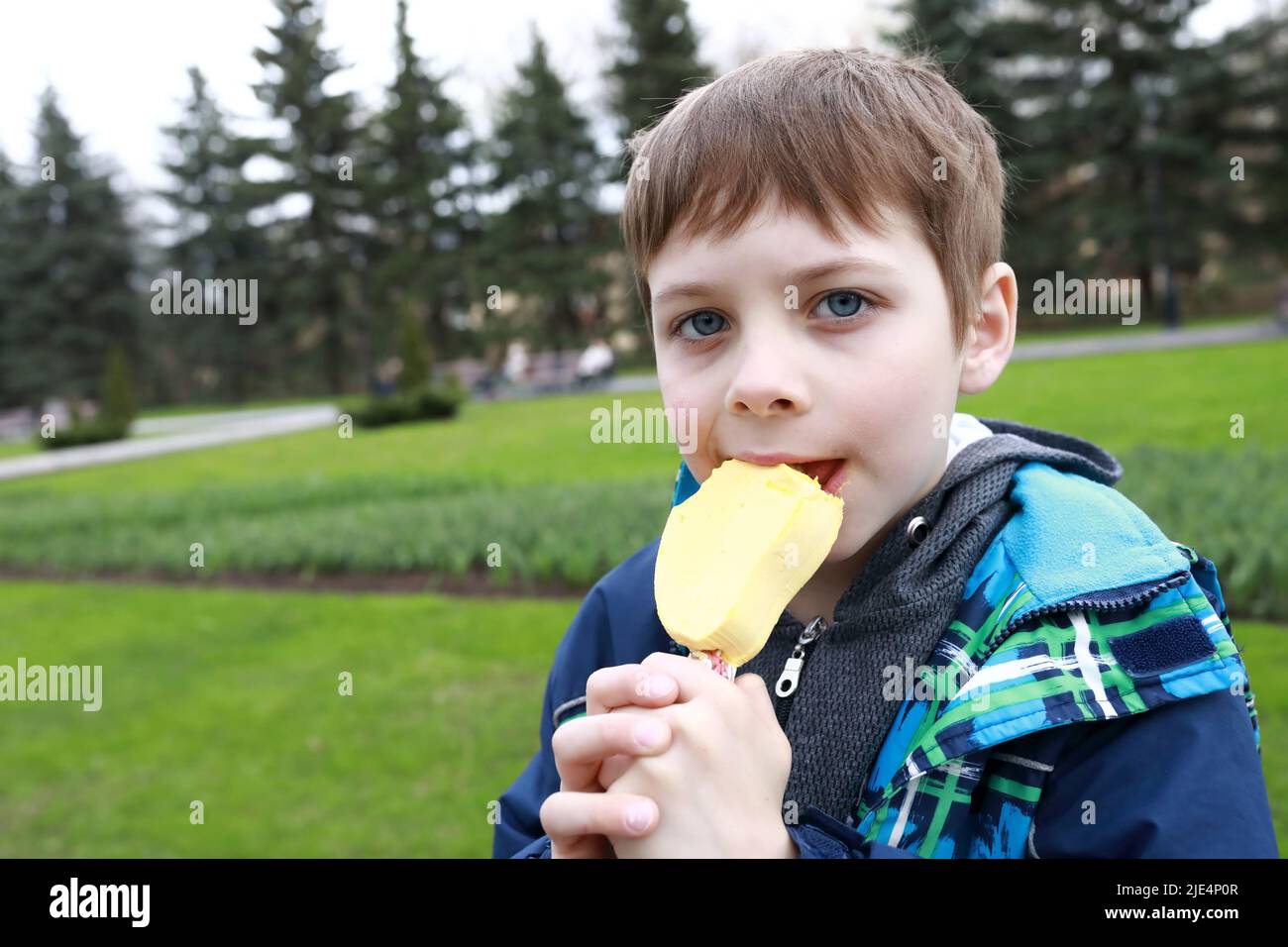 Kinder essen Mango-Eis im Park Stockfoto