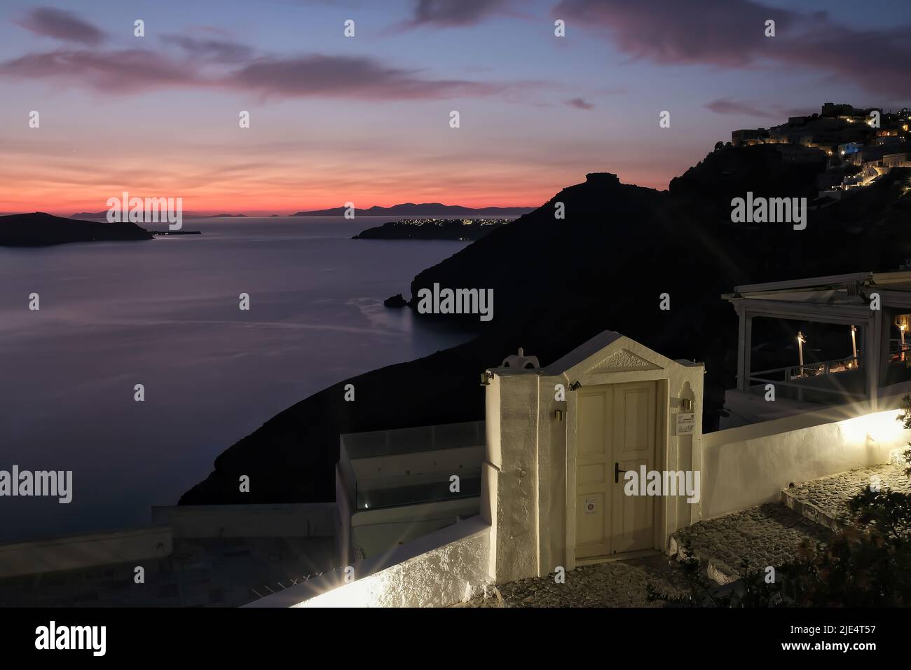 Santorini, Griechenland - 12. Mai 2021 : Blick auf den Eingang eines traditionellen Hotels und einen violetten Sonnenuntergang in Fira Santorini Stockfoto