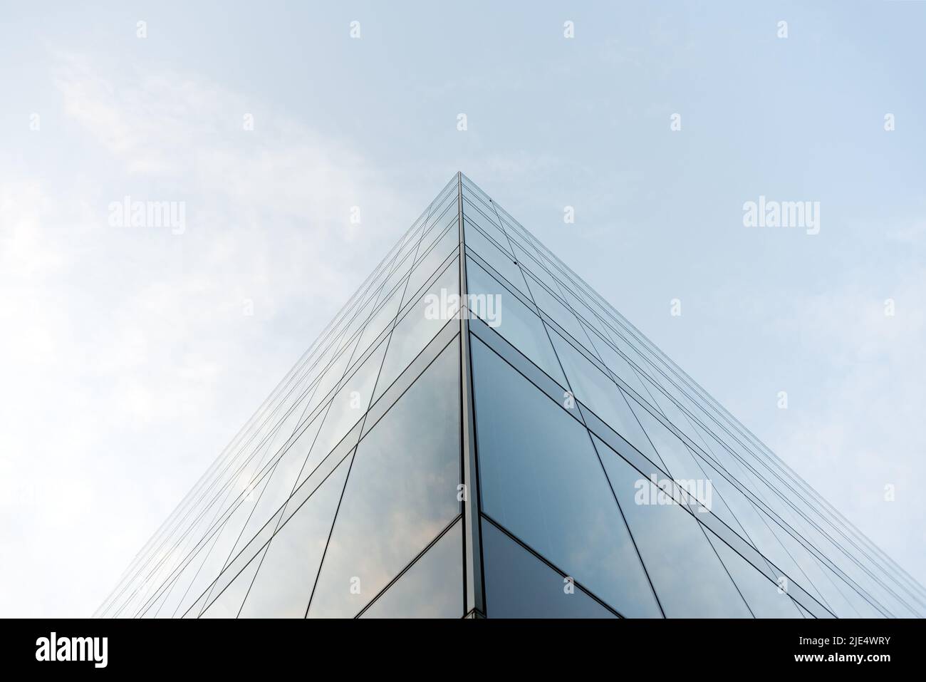 Das Dach eines modernen Glasgebäudes liegt vor hellem Himmel Stockfoto