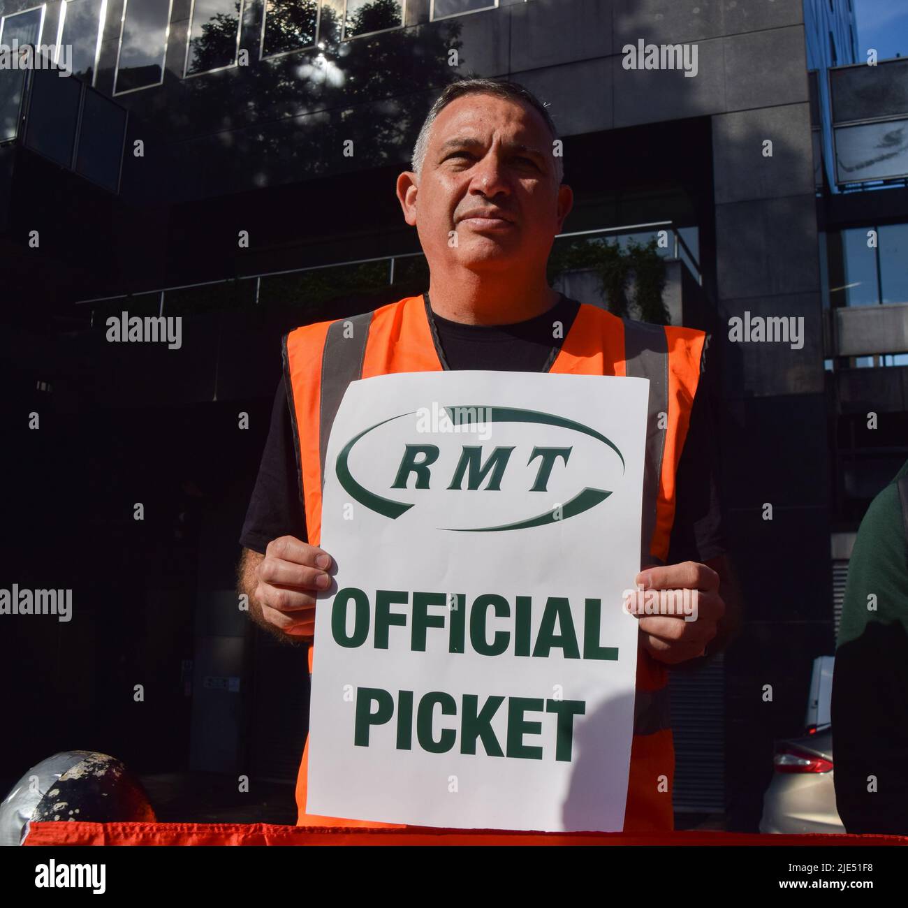 London, England, Großbritannien. 25.. Juni 2022. Ein Mitglied der RMT-Gewerkschaft hält am dritten Tag des landesweiten Eisenbahnstreiks vor dem Bahnhof Euston ein Plakat mit einem „offiziellen Streikposten“. Die Gewerkschaft RMT (Rail, Maritime and Transport Workers) veranstaltet Streikposten aus Protest gegen unbefriedigende Löhne, staatliche Kürzungen und Arbeitsbedingungen. (Bild: © Vuk Valcic/ZUMA Press Wire) Bild: ZUMA Press, Inc./Alamy Live News Stockfoto